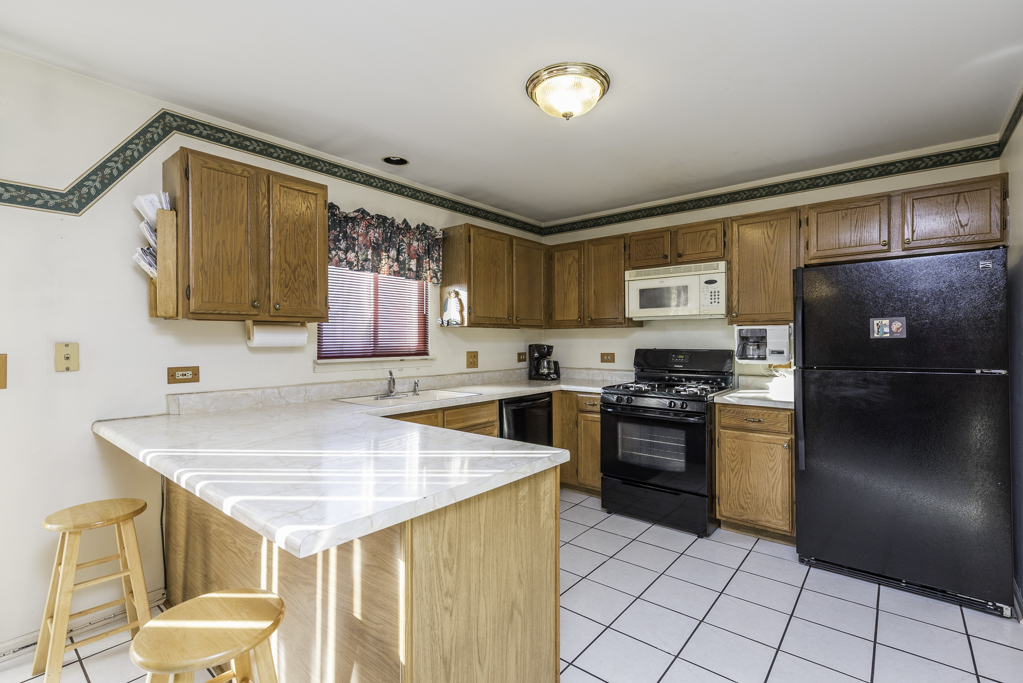 1834 Arbor Court Gurnee, IL 60031 - Photo 5 of 31 a kitchen with a sink a stove a refrigerator and blue cabinets