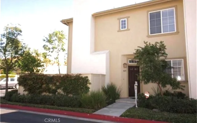 a front view of a house with plants