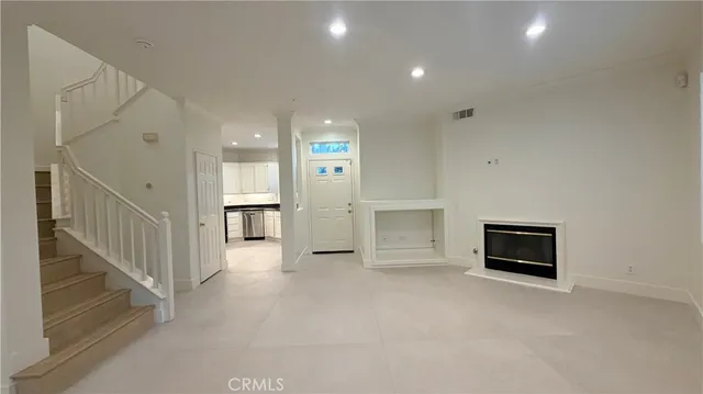 a view of an empty room with wooden floor and a cabinet