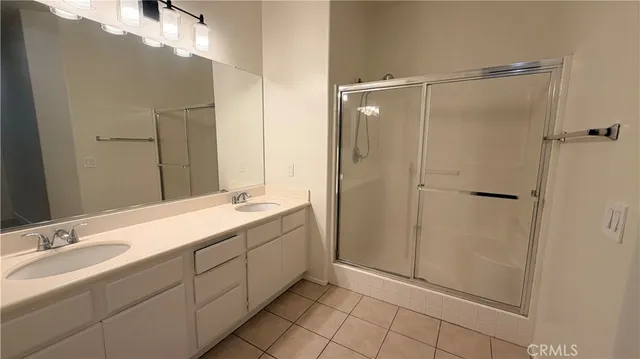 a bathroom with a double vanity sink mirror and shower