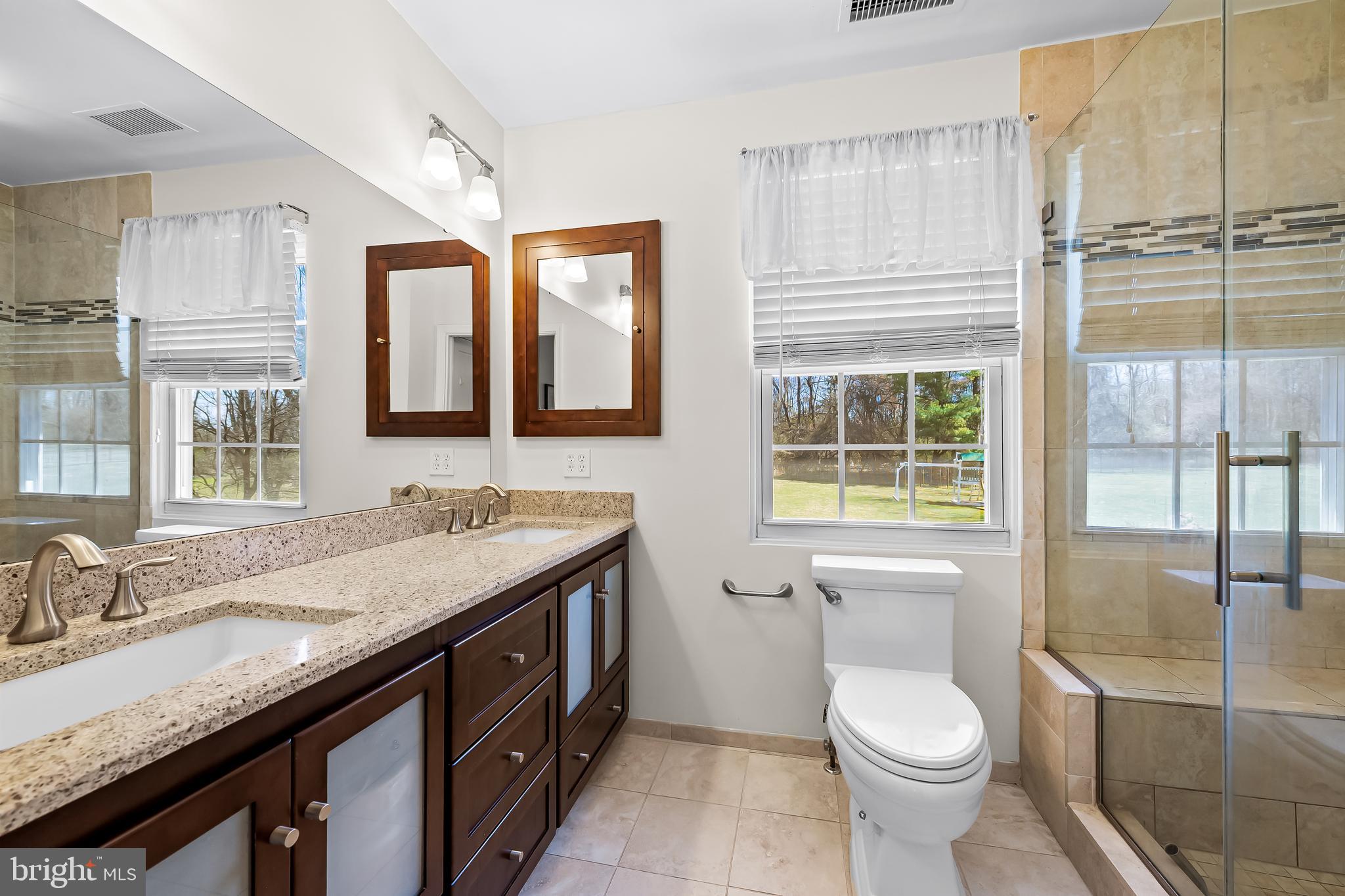 14305 Robcaste Road Phoenix, MD 21131 - Photo 30 of 53 a bathroom with a granite countertop sink mirror vanity and toilet