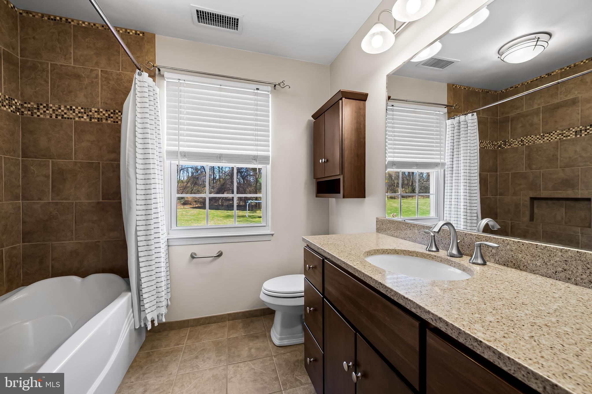 14305 Robcaste Road Phoenix, MD 21131 - Photo 38 of 53 a bathroom with a granite countertop sink toilet and shower