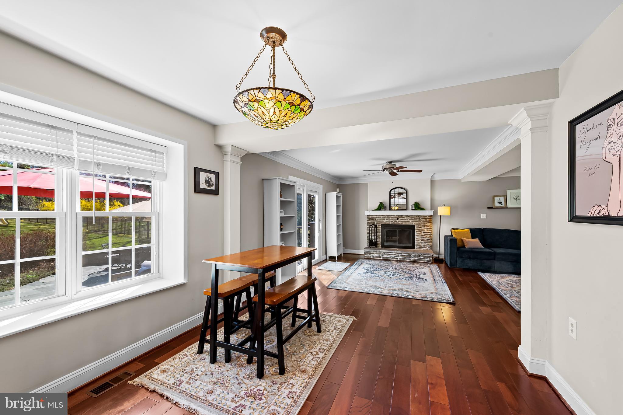 14305 Robcaste Road Phoenix, MD 21131 - Photo 10 of 53 a view of a dining room and livingroom with furniture wooden floor a rug a chandelier and a window