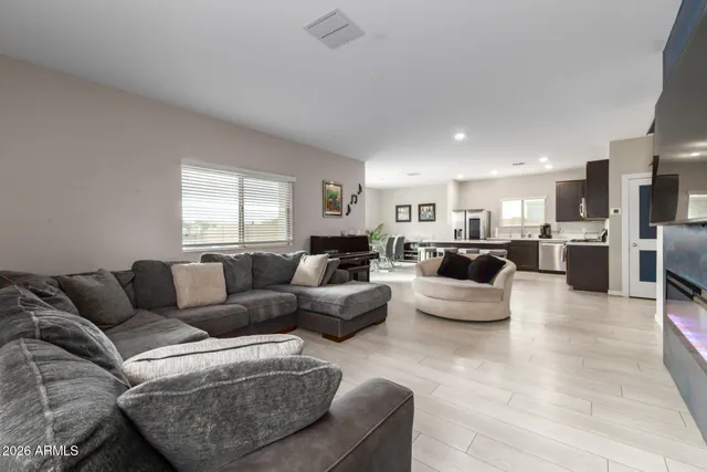 a living room with furniture white walls and kitchen view