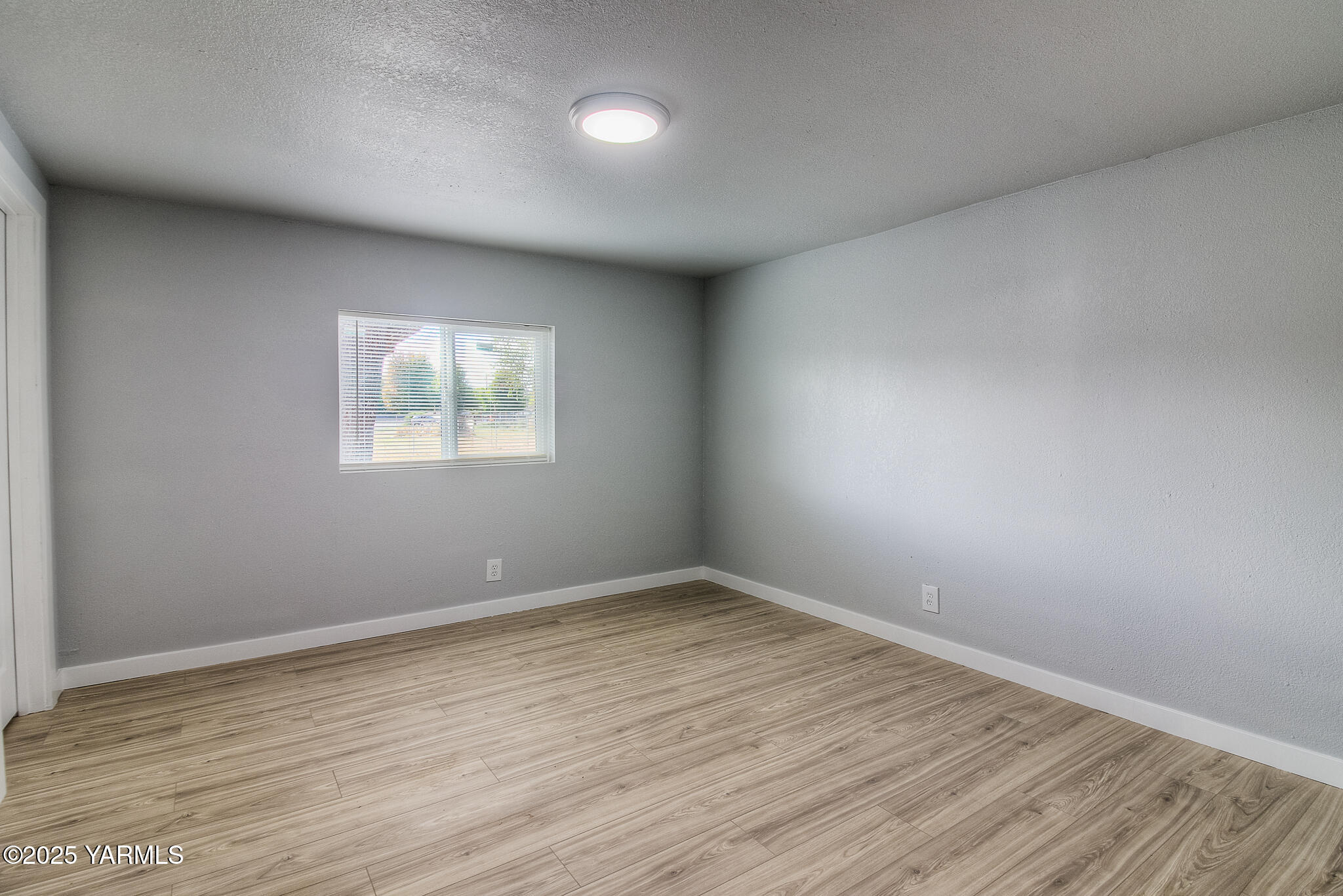 10420 Ahtanum Road Yakima, WA 98903 - Photo 12 of 24 an empty room with wooden floor and windows