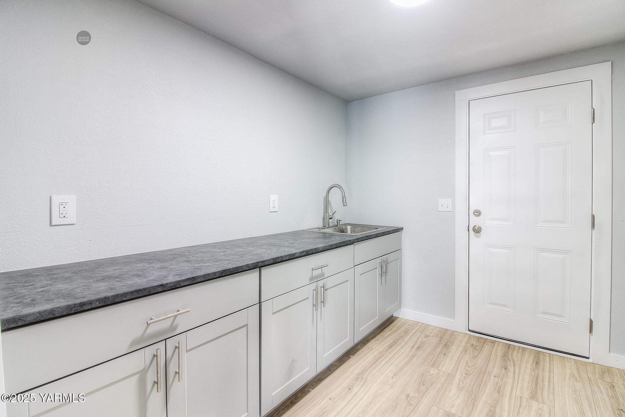 10420 Ahtanum Road Yakima, WA 98903 - Photo 18 of 24 a hallway with granite countertop white cabinets and a wooden floor