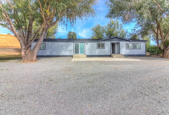 a front view of a house with a yard and trees