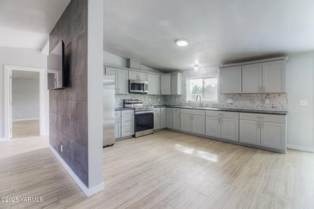 a large kitchen with cabinets and stainless steel appliances