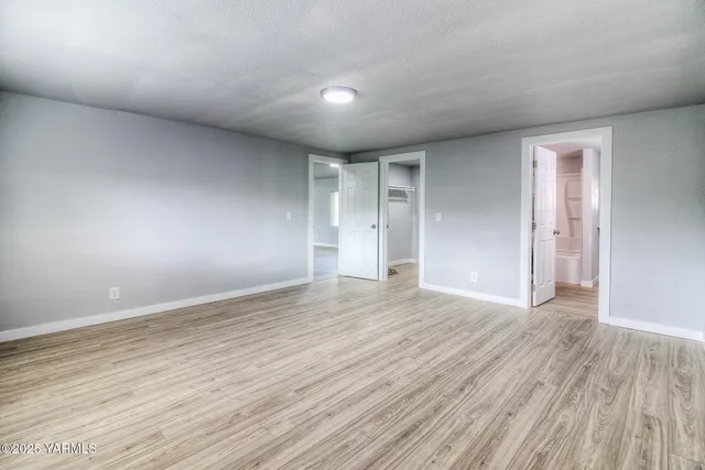 a view of empty room with wooden floor