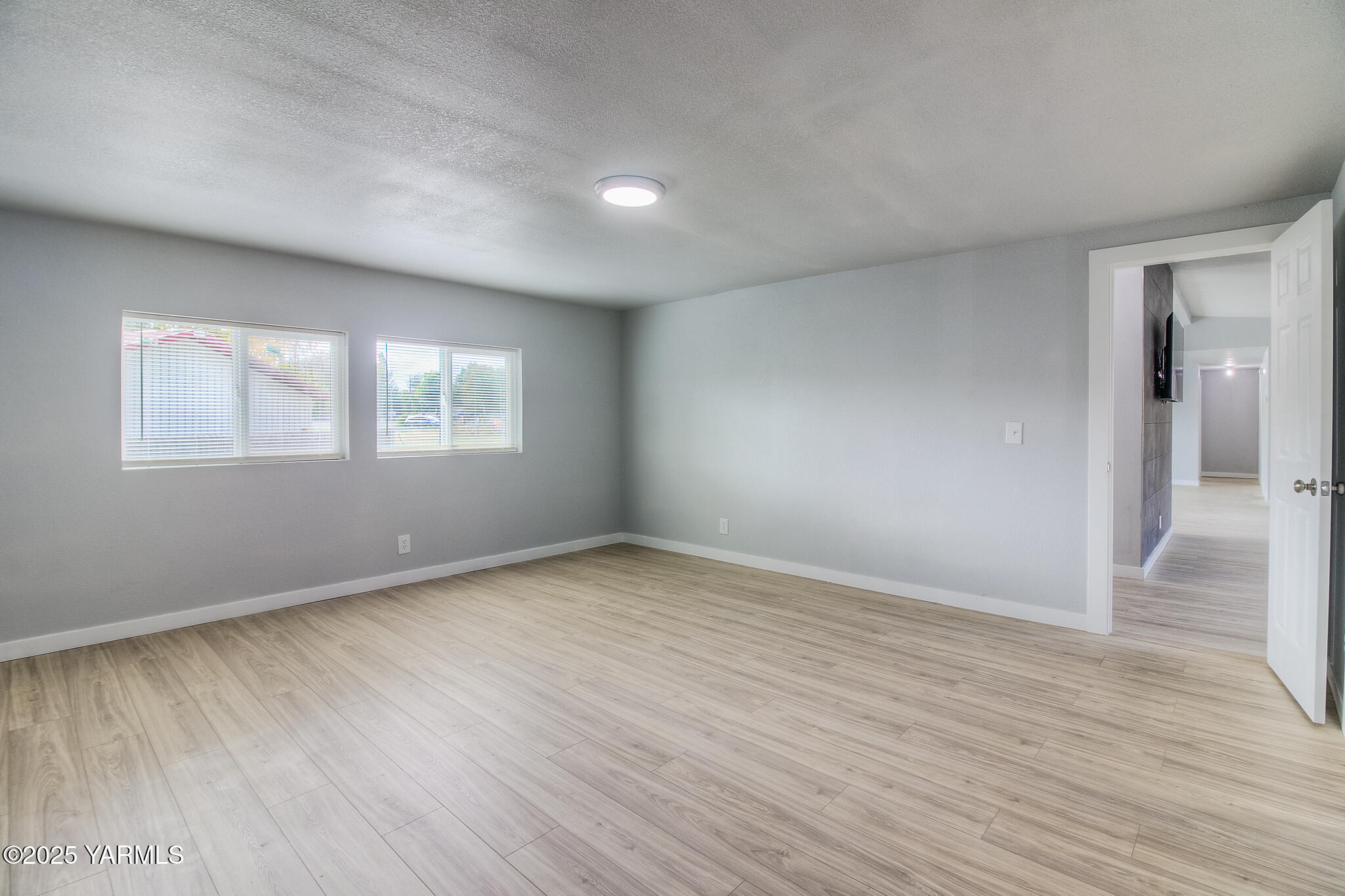 10420 Ahtanum Road Yakima, WA 98903 - Photo 9 of 24 an empty room with wooden floor and windows