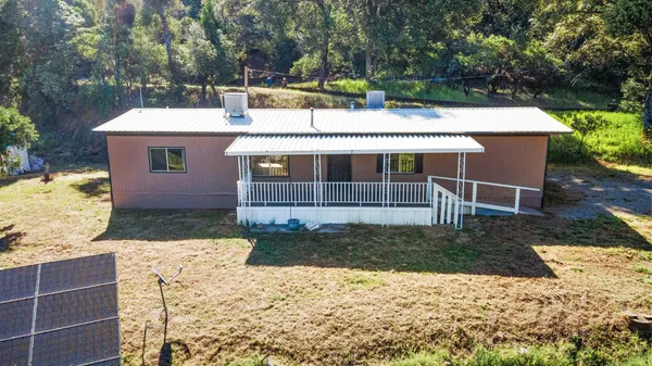 a view of backyard of house with wooden fence