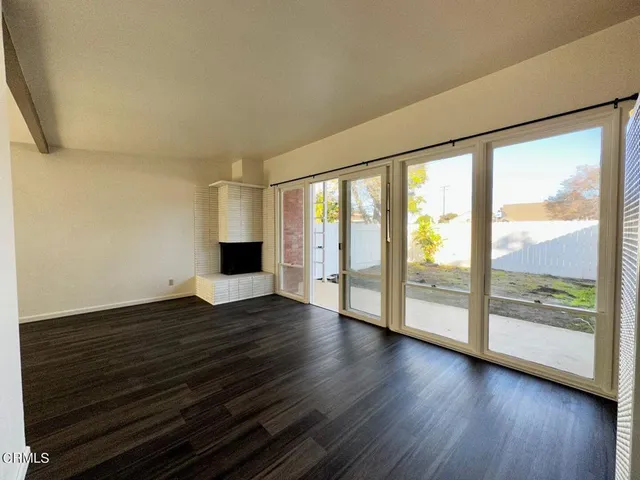 a view of empty room with wooden floor and fireplace