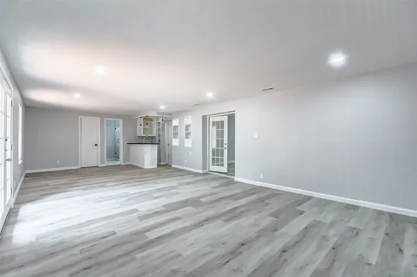 an empty room with wooden floor and windows