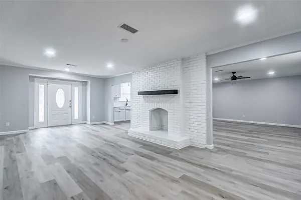 a view of empty room with wooden floor and fireplace