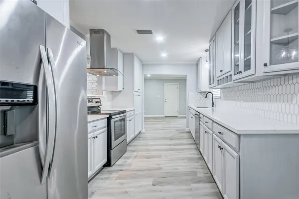a kitchen with stainless steel appliances a refrigerator and a stove