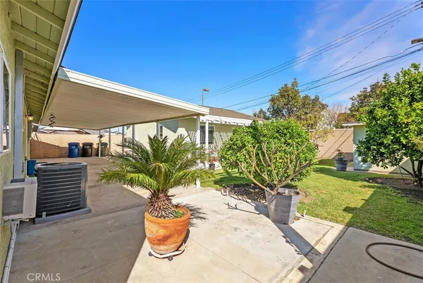 a patio with table and chairs and potted plants