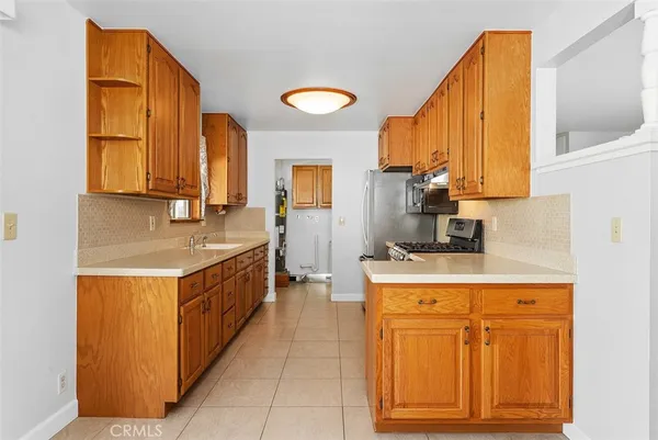 a kitchen with stainless steel appliances granite countertop a sink a stove and a refrigerator