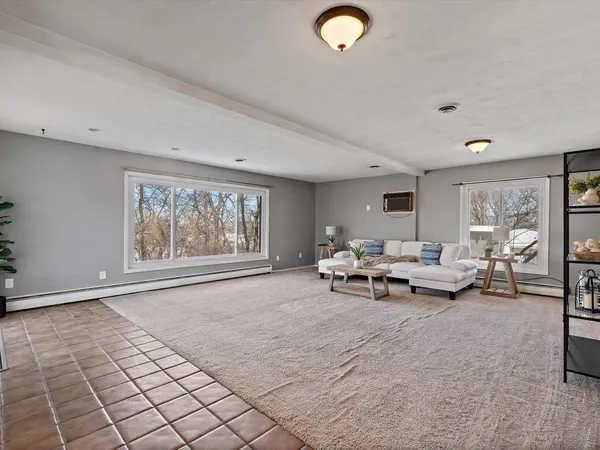 a view of a dining room with furniture large window a chandelier and wooden floor