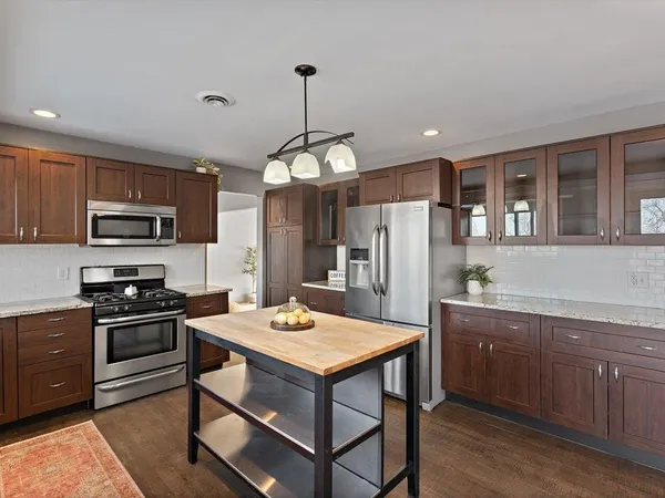a kitchen that has a lot of cabinets and wooden floor