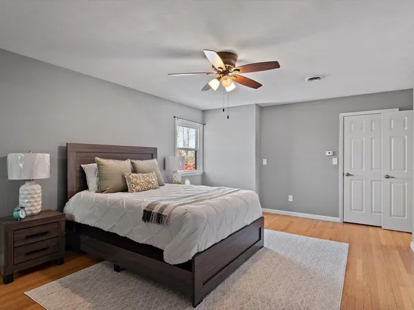 a view of an empty room with window and wooden floor