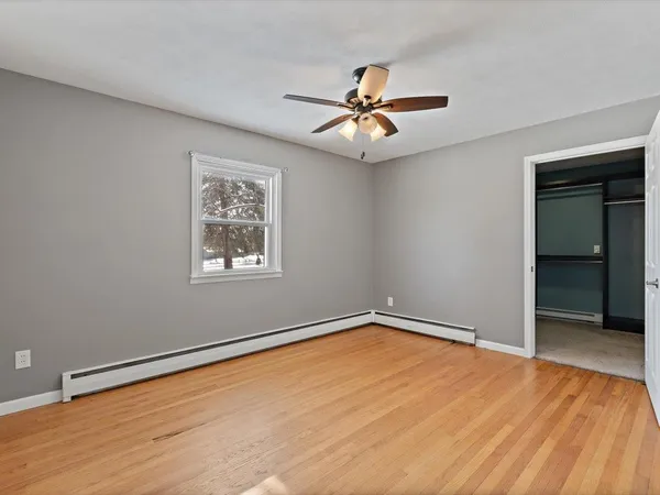 a view of a big room with wooden floor and windows