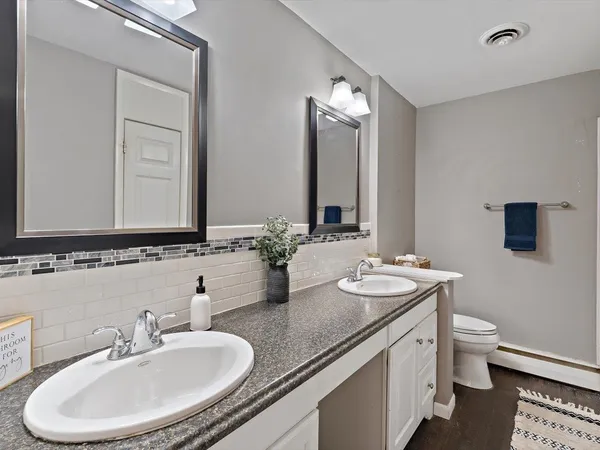 an empty room with wooden floor chandelier fan and windows