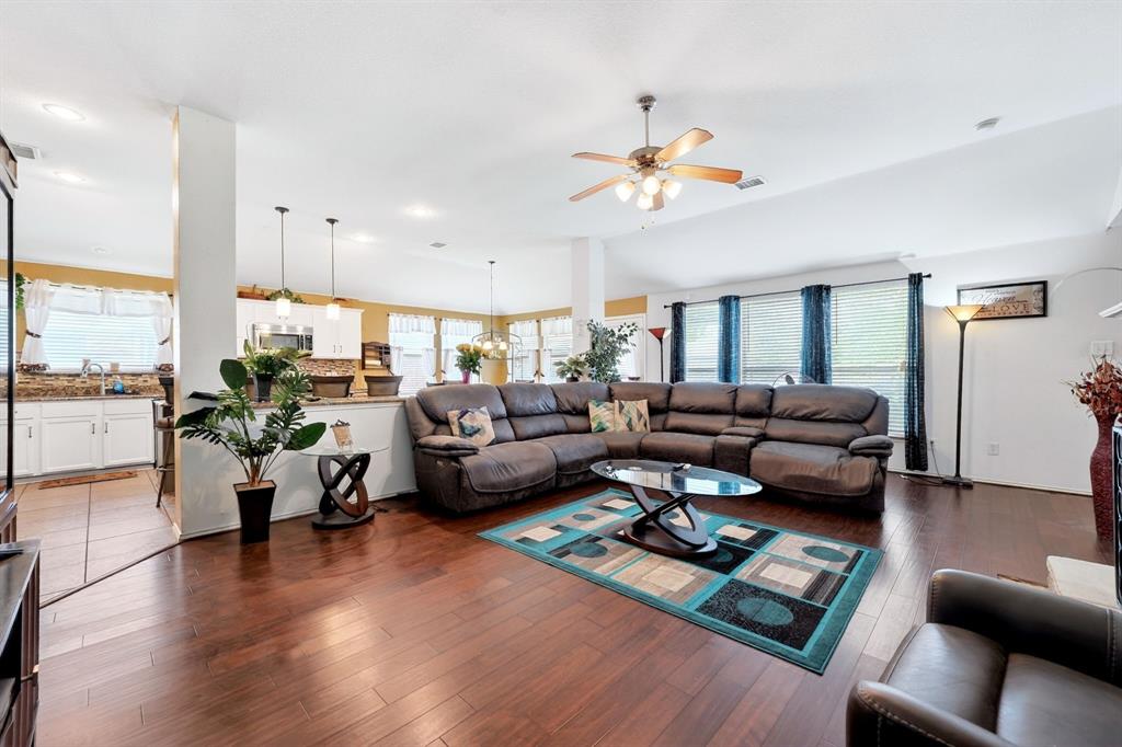 511 Chestnut Trail Forney, TX 75126 - Photo 12 of 32 Spacious living area featuring wood-finish flooring, a vaulted ceiling, and ample natural light from multiple windows