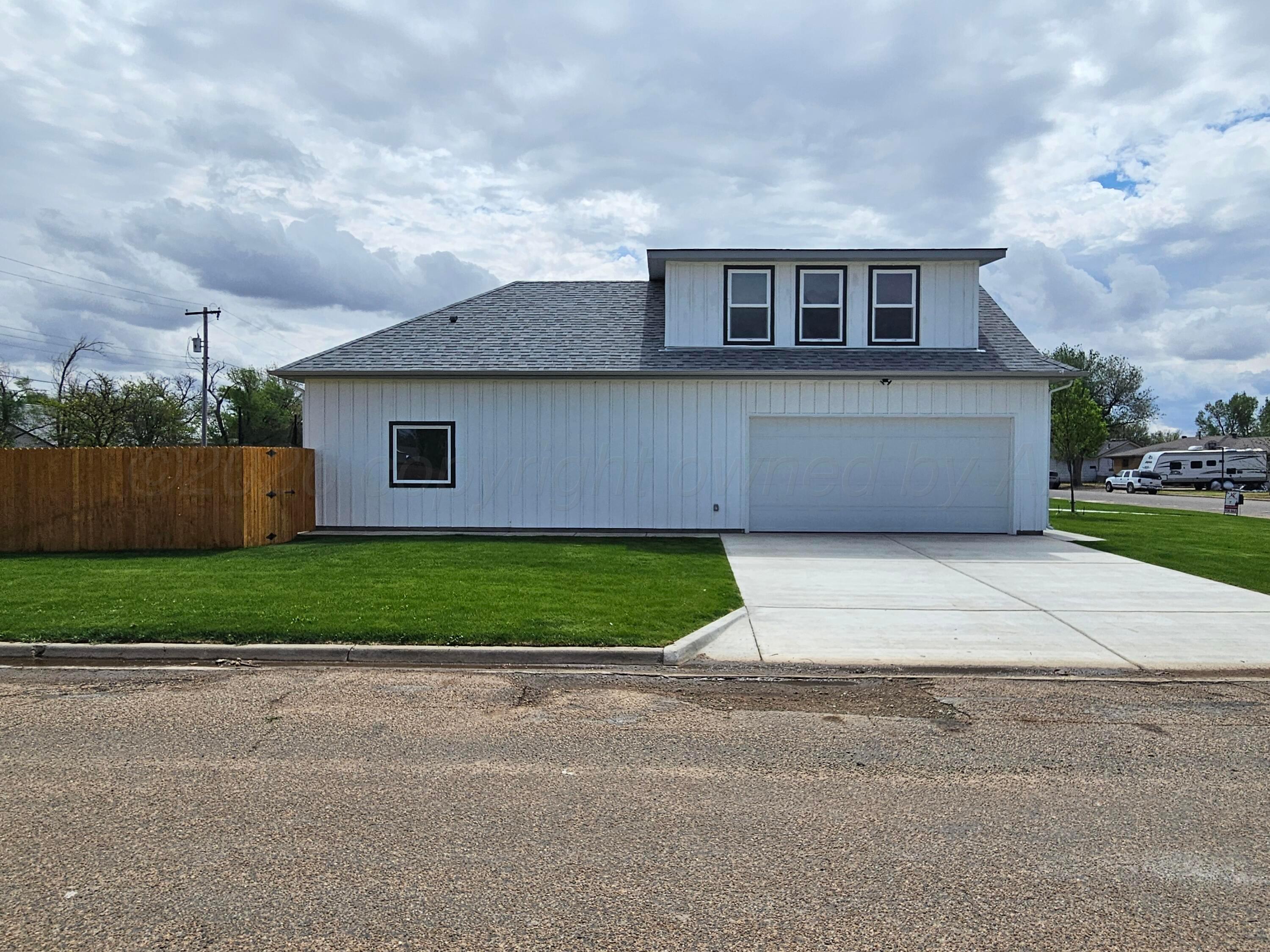 1010 Oak Avenue Panhandle, TX 79068 - Photo 3 of 44 a front view of a house with a garden and garage