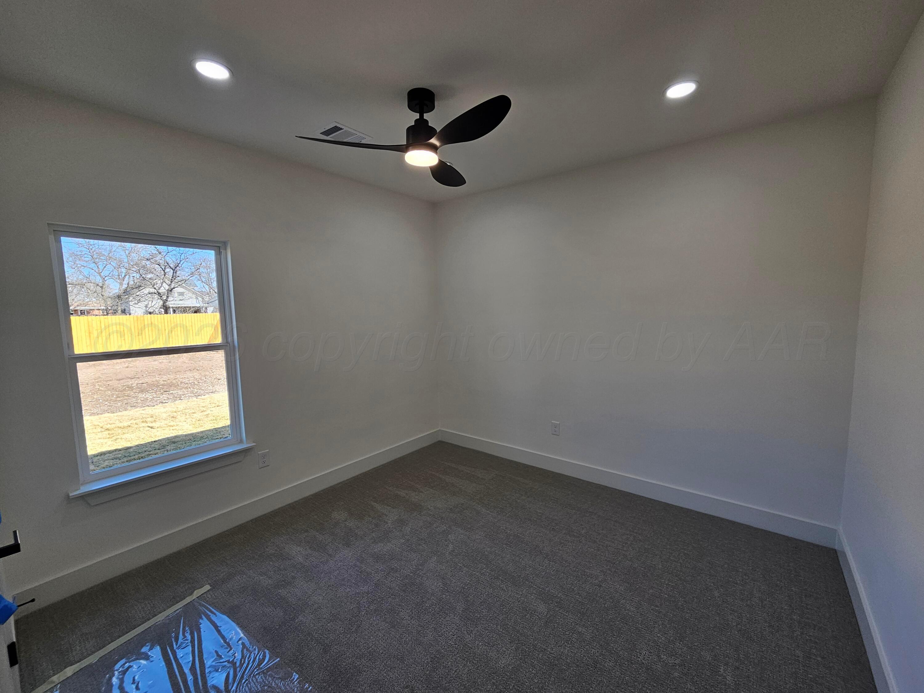 1010 Oak Avenue Panhandle, TX 79068 - Photo 39 of 44 an empty room with a window and a ceiling fan