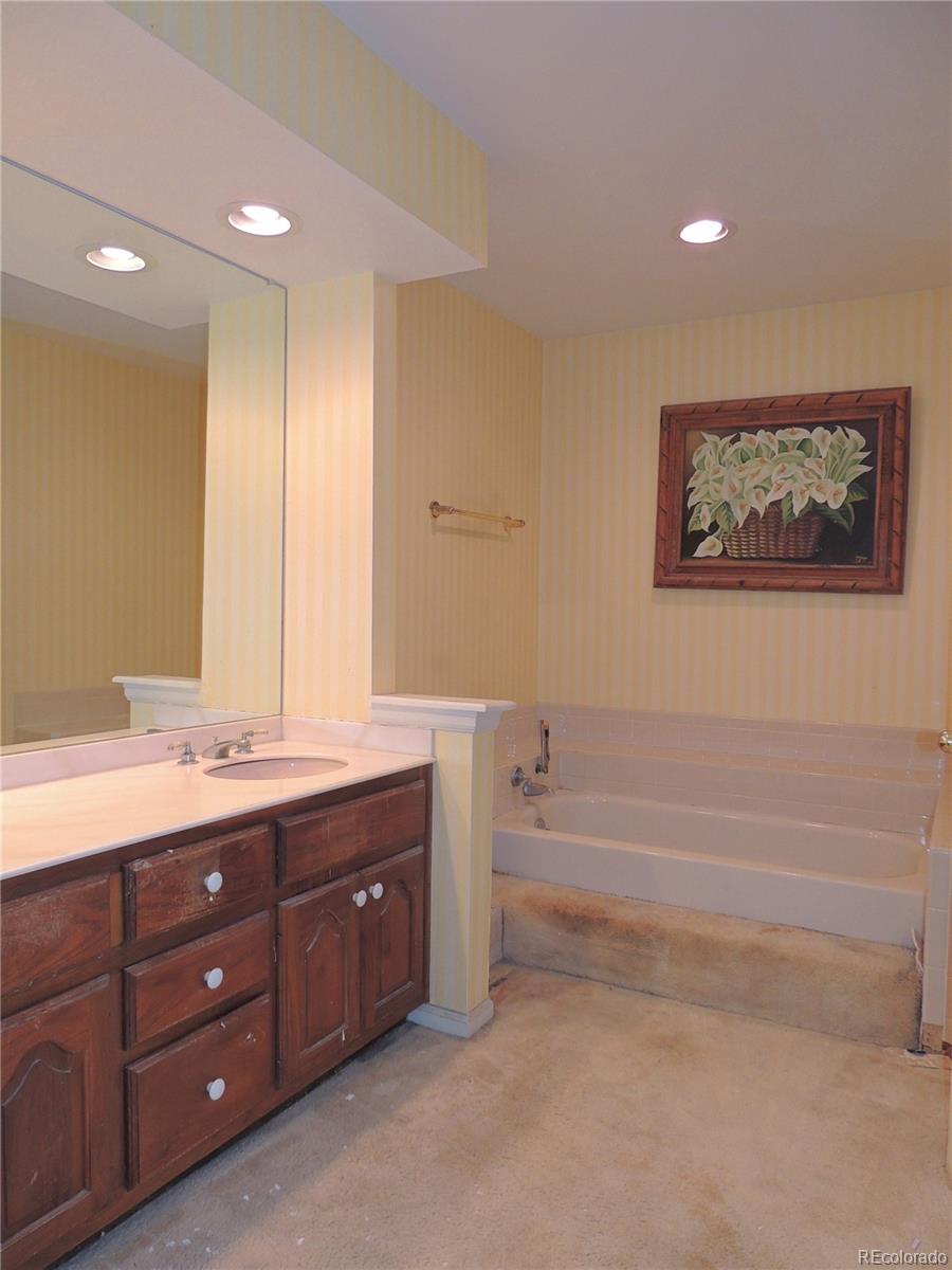 4530 South Verbena Street, Unit 322 Denver, CO 80237 - Photo 18 of 27 a spacious bathroom with a double vanity sink large mirror and a bathtub
