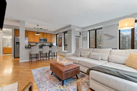 a living room with furniture wooden floor and a kitchen view