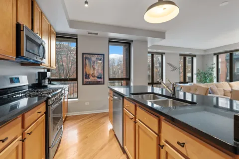 a large kitchen with stainless steel appliances granite countertop a lot of counter space and a sink
