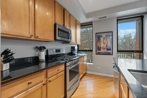 a kitchen with stainless steel appliances granite countertop a stove a sink and a microwave