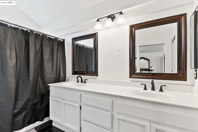 a bathroom with double vanity sink and a mirror