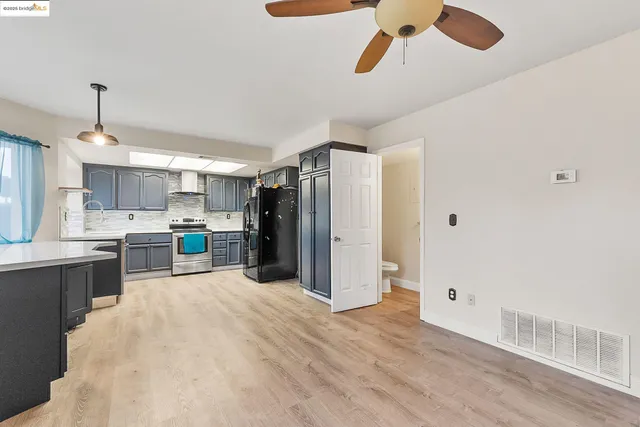 a kitchen with stainless steel appliances kitchen island a refrigerator sink and cabinets