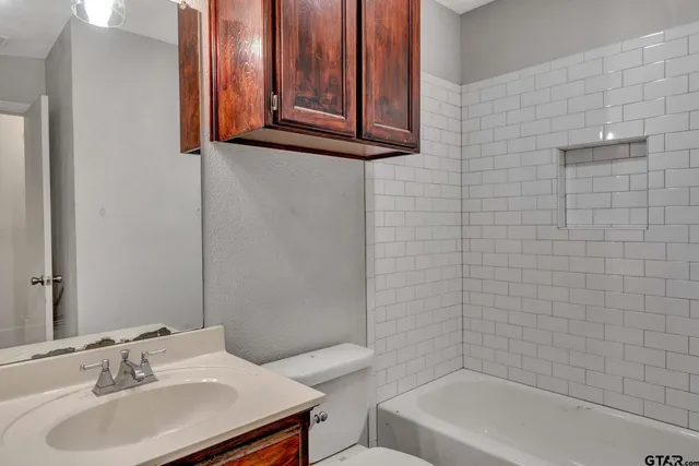 a bathroom with a sink a toilet and tub