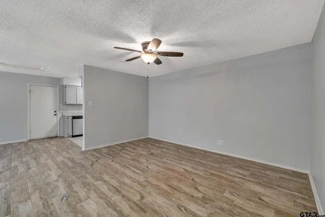 a view of empty room with wooden floor