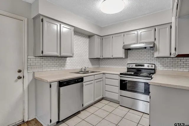 a kitchen with cabinets stainless steel appliances and sink