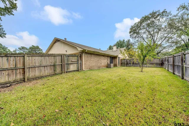 a view of a house with backyard and tree