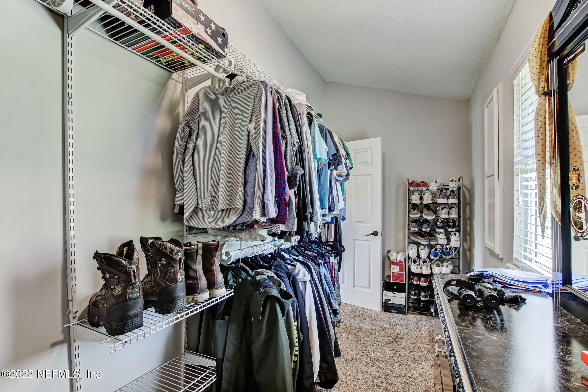75004 Edwards Road Yulee, FL 32097 - Photo 26 of 62 a view of walk in closet with clothes and shoes
