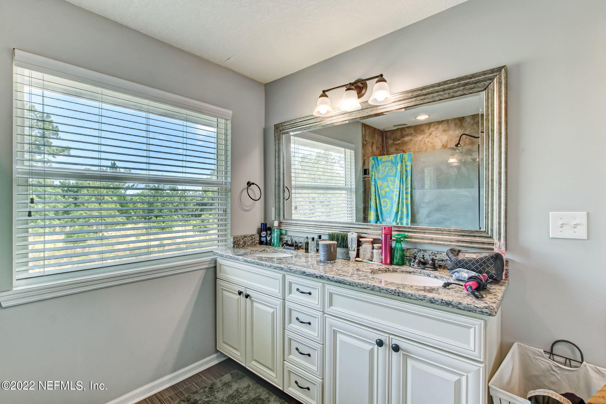 75004 Edwards Road Yulee, FL 32097 - Photo 27 of 62 a bathroom with a sink and a large mirror next to a window