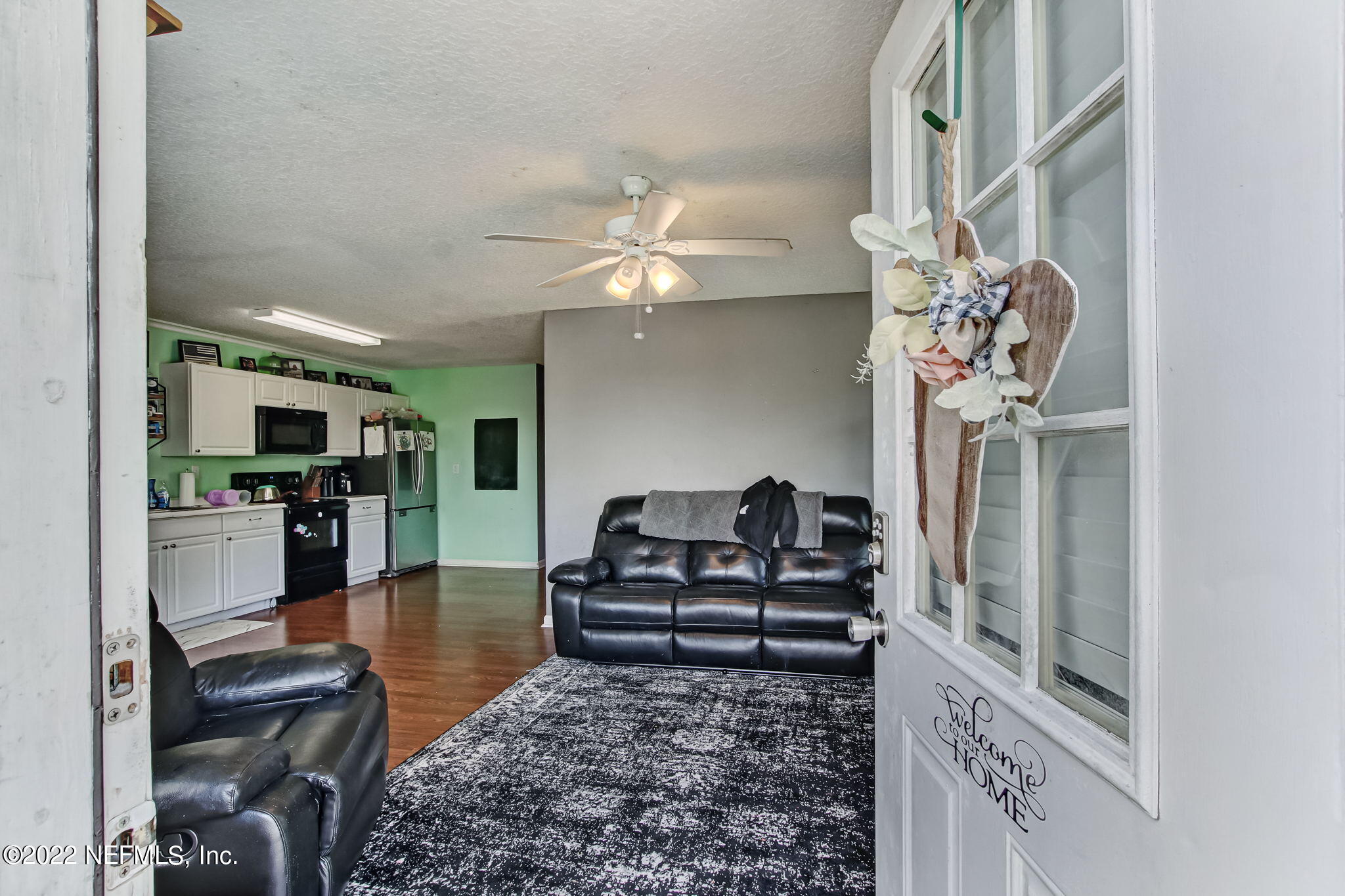 75004 Edwards Road Yulee, FL 32097 - Photo 38 of 62 a living room with furniture and a chandelier