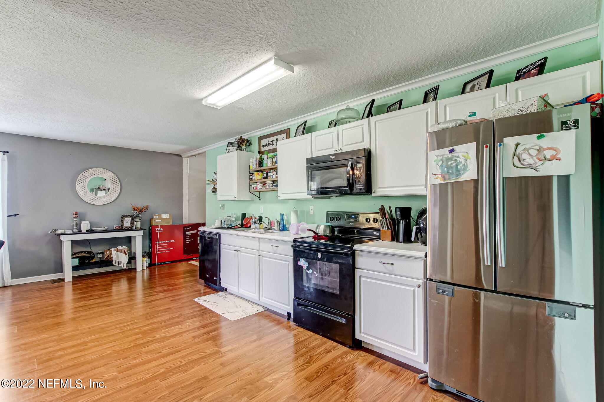 75004 Edwards Road Yulee, FL 32097 - Photo 42 of 62 a kitchen with a refrigerator and a stove top oven