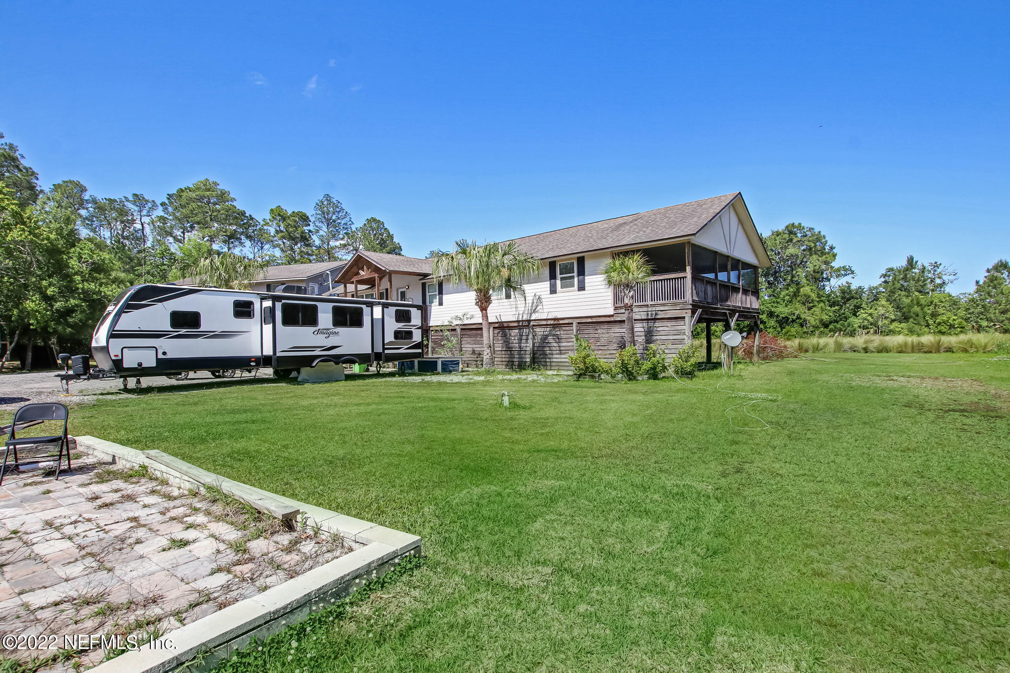 75004 Edwards Road Yulee, FL 32097 - Photo 7 of 62 a front view of a house with a yard table and chairs