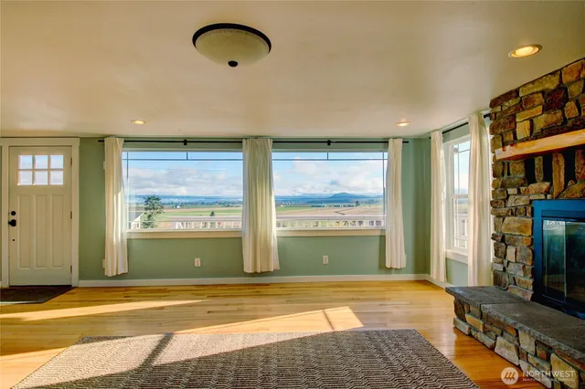 a view of an empty room with a fireplace and a window