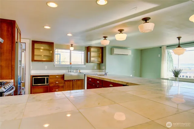 a large kitchen with stainless steel appliances a stove a sink dishwasher and a refrigerator with wooden floor