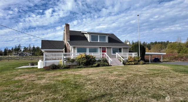a front view of house with yard and trees in the background