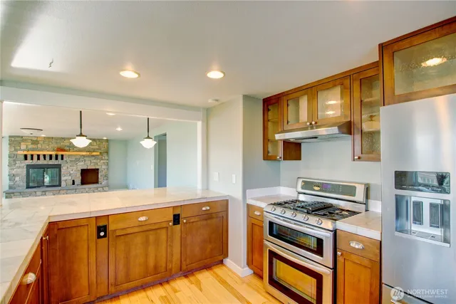 a kitchen with stainless steel appliances granite countertop a stove a sink and a refrigerator