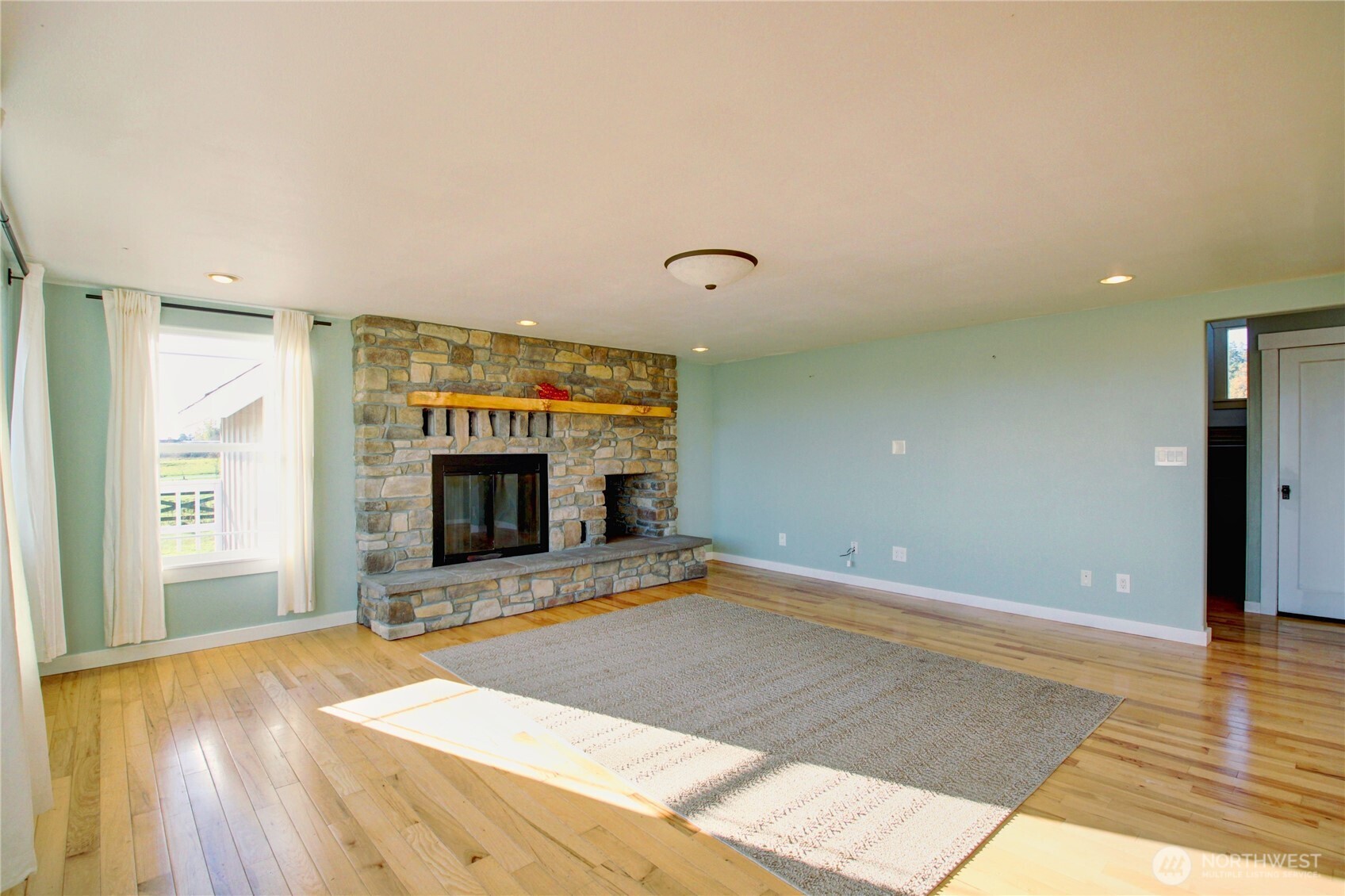 18122 Best Road Mount Vernon, WA 98273 - Photo 10 of 40 a view of an empty room with wooden floor and a fireplace
