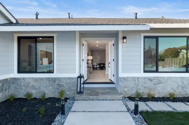 a view of a chairs and table in the back yard of a house